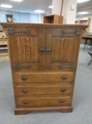 An oak linen fold cabinet fitted three drawers