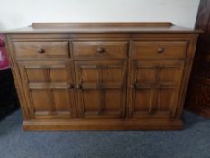 An Ercol triple door sideboard sideboard fitted with three drawers