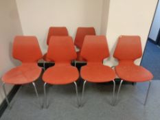 Six 20th century Danish stacking chairs upholstered in a red fabric on tubular metal legs