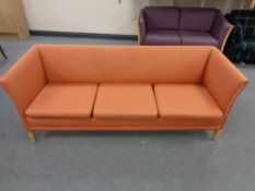 A 20th century Danish three seater settee in burnt orange fabric