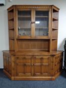 An Ercol double door glazed display cabinet fitted cocktail cupboard and two matching corner