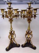 A pair of ornate brass six way table candelabra on black marble bases, height 53.