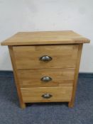 A contemporary oak three drawer bedside chest