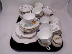 A tray containing Belleek flowers of the month lidded trinket pot together with a further china