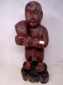 A carved painted wooden figure of a man with Koi fish.