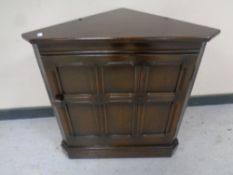An Ercol elm and beech corner cupboard