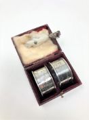 A cased pair of silver napkin rings together with a Scottish white metal mounted talon brooch