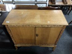 A carved oak two door side cabinet