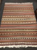 A flatweave kilim on polychrome ground, 200 cm x 144 cm.