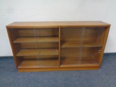 A mid 20th century teak sliding glass door bookcase