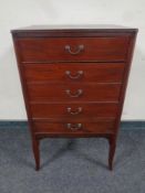 An Edwardian five drawer music chest on raised legs