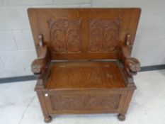 An Edwardian carved oak monk's bench