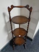 An Edwardian oak barley twist three tier cake stand
