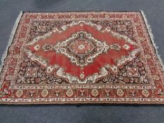 A fringed Iranian woolen rug of geometric design on black and red ground