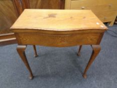 An Edwardian oak serpentine fronted cutlery table