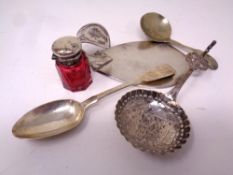 A small silver topped ruby glass jar together with three pieces of silver cutlery and a further