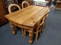 A carved pine dining table together with a set of four balloon back dining chairs