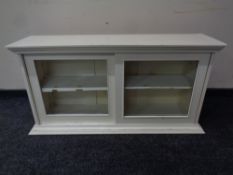 An Edwardian painted sliding door wall cabinet