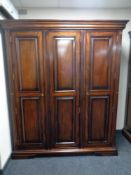 A contemporary mahogany effect triple door wardrobe