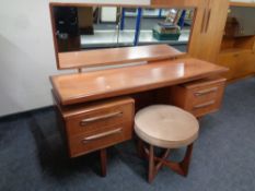 A 20th century teak G plan knee hole dressing table fitted four drawers with circular stool