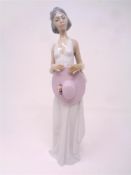 A Lladro figure of a woman in white dress holding a summer hat