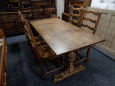 An oak refectory dining table together with a set of four rush seated ladder back dining chairs