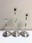 A set of three graduated loaded silver twist candlesticks, stamped 800, tallest 26cm.