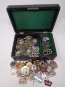 A jewelry box containing a quantity of key rings and medals