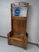 An Edwardian carved oak mirrored hall stand with storage seat