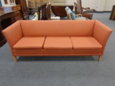 A twentieth century Danish three seater settee upholstered in a burnt orange fabric