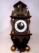 A decorative Dutch wall clock with brass pear drop weights