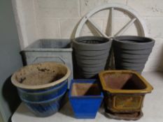 A plastic cartwheel together with six assorted planters