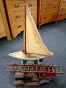 A vintage tin plated fire engine together with a pond yacht on stand