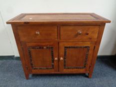 A stained pine side cabinet fitted cupboards and drawers beneath