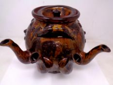 A very large folk art slipware four spouted stone ware teapot with applied decoration of lions and
