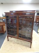 An Edwardian mahogany double door glazed bookcase on raised legs