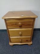 A pine three drawer bedside chest