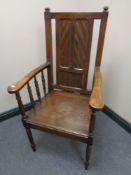 An Edwardian oak and beech panel backed armchair
