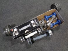 A weights bar and weights together with a box of dumbbells and weights,