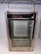 A metal and glass terrarium with carry handle