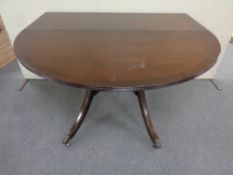 A Regency style drop leaf table on brass capped paw feet