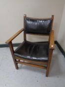 An early 20th century oak child's armchair in brown studded leather