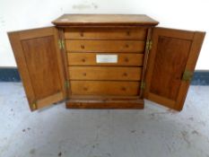 An oak two door collector's cabinet fitted internal drawers