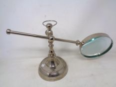 A chrome desk magnifier