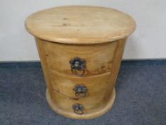 An oval pine three drawer chest