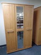 A contemporary wood effect triple door wardrobe