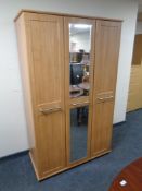 A contemporary wood effect triple door wardrobe