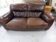 A contemporary brown leather two seater settee