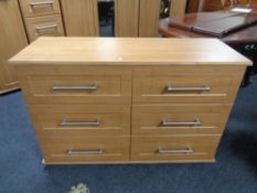 A contemporary wood effect six drawer chest