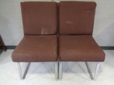 A pair of office chairs on chrome legs